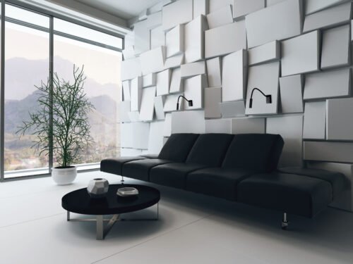Black couch in front of white ornamental wall